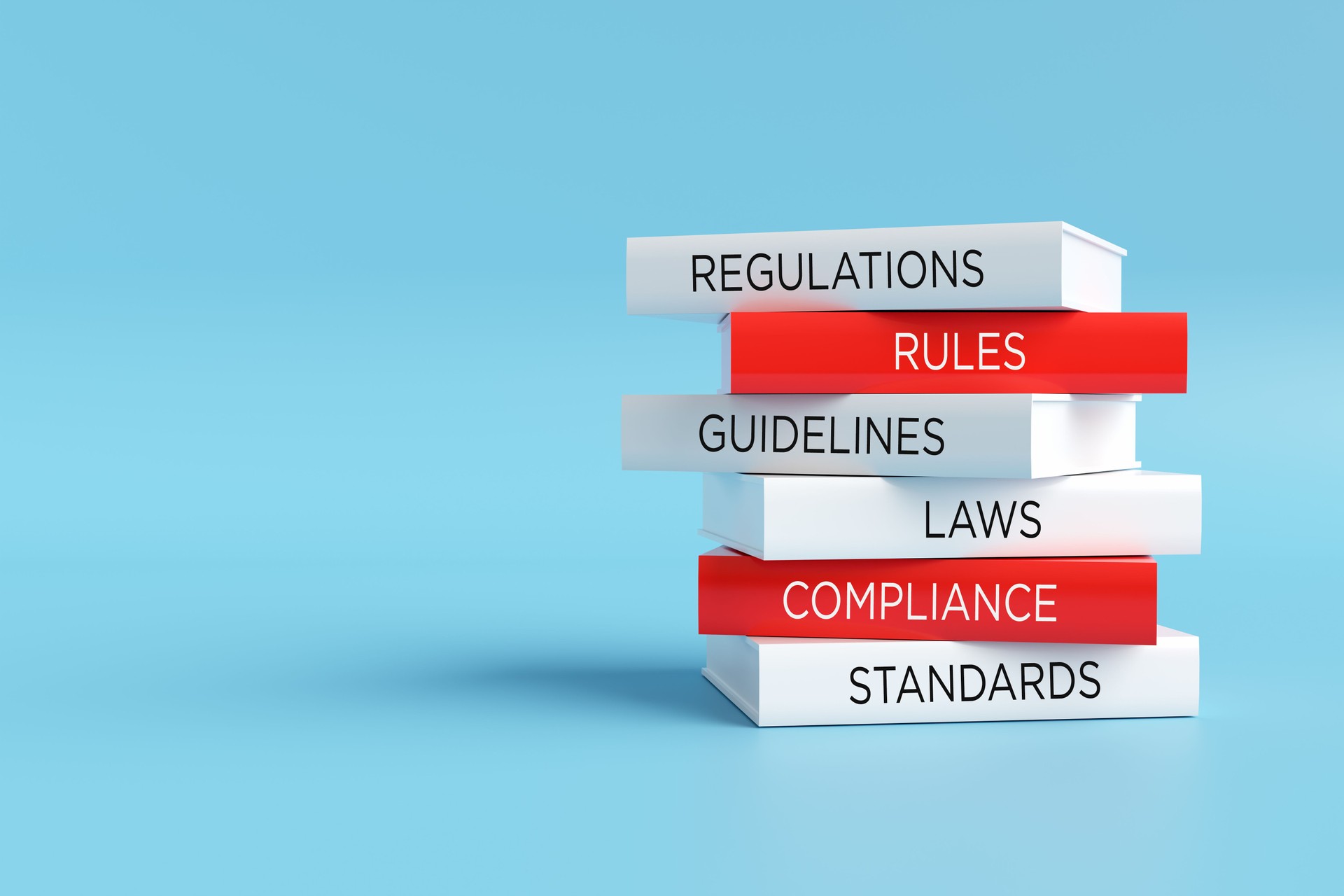 Stack of books representing regulatory compliance and legal standards
